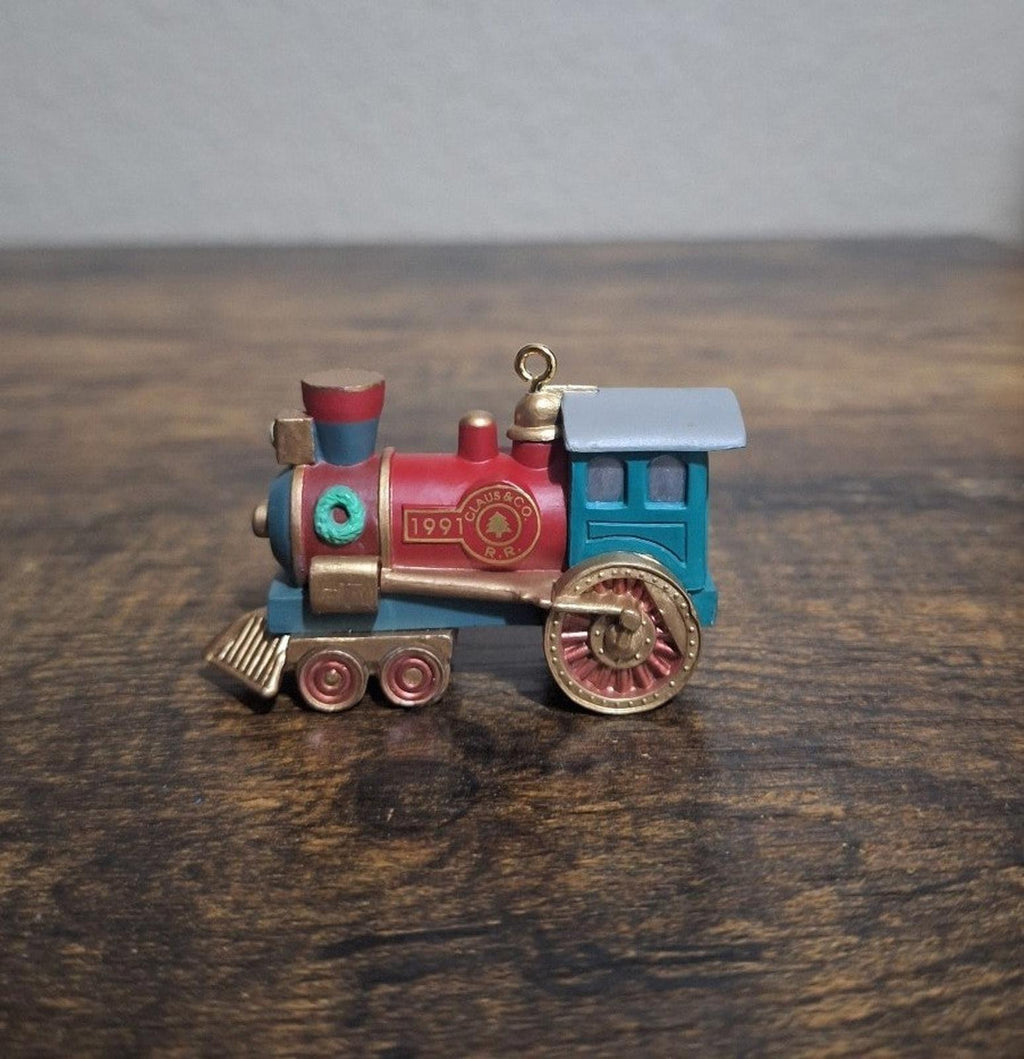 Blue and red train locomotive ornament, side view with red center badge and hanging loop