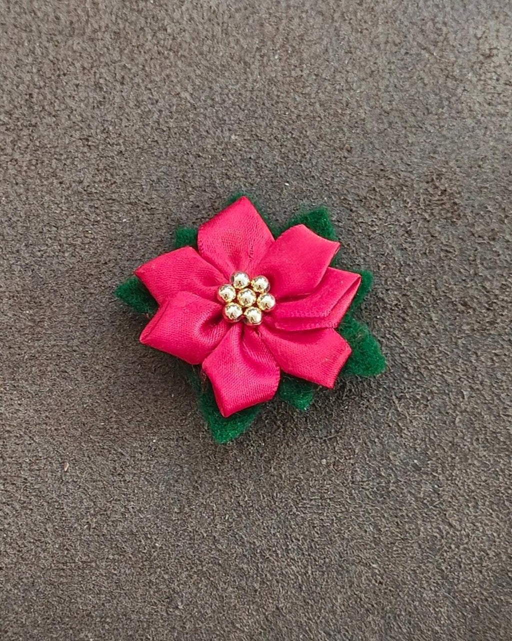 Red poinsettia fabric flower brooch with layered petals and gold bead center