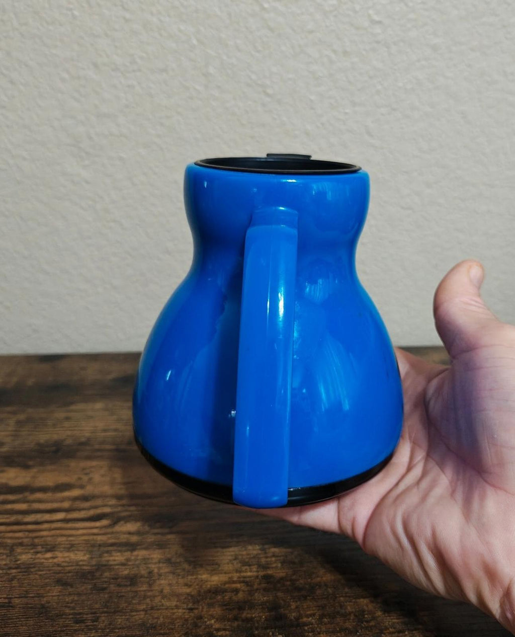 Blue Minolta hard-plastic mug viewed from front, rounded body and top rim
