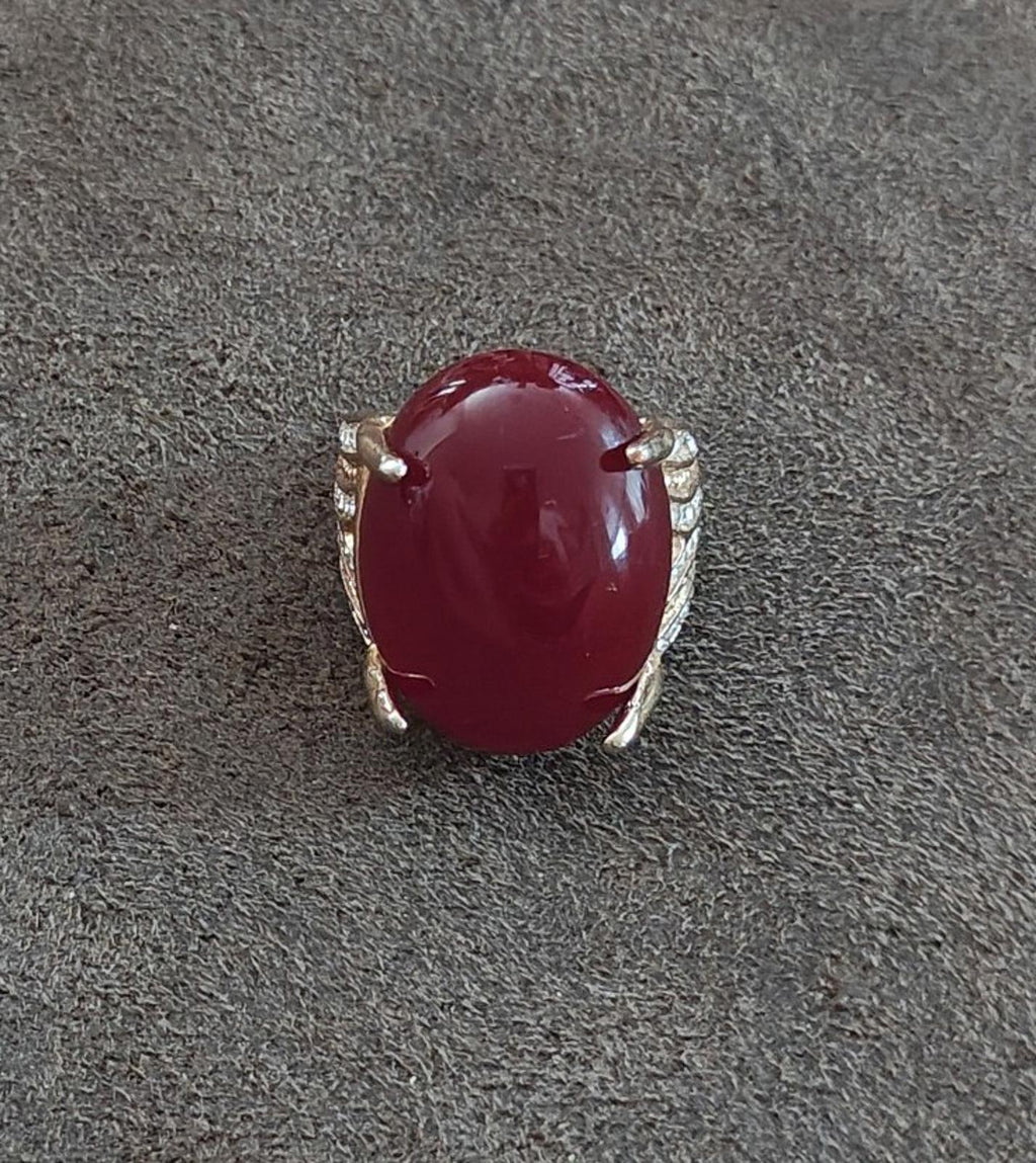 Red oval faux stone ring with gold-tone halo and clear rhinestone side accents