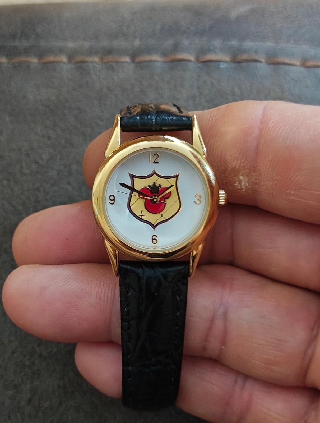 Quartz wristwatch with gold-tone case, black leather strap, and Mickey-style dial.