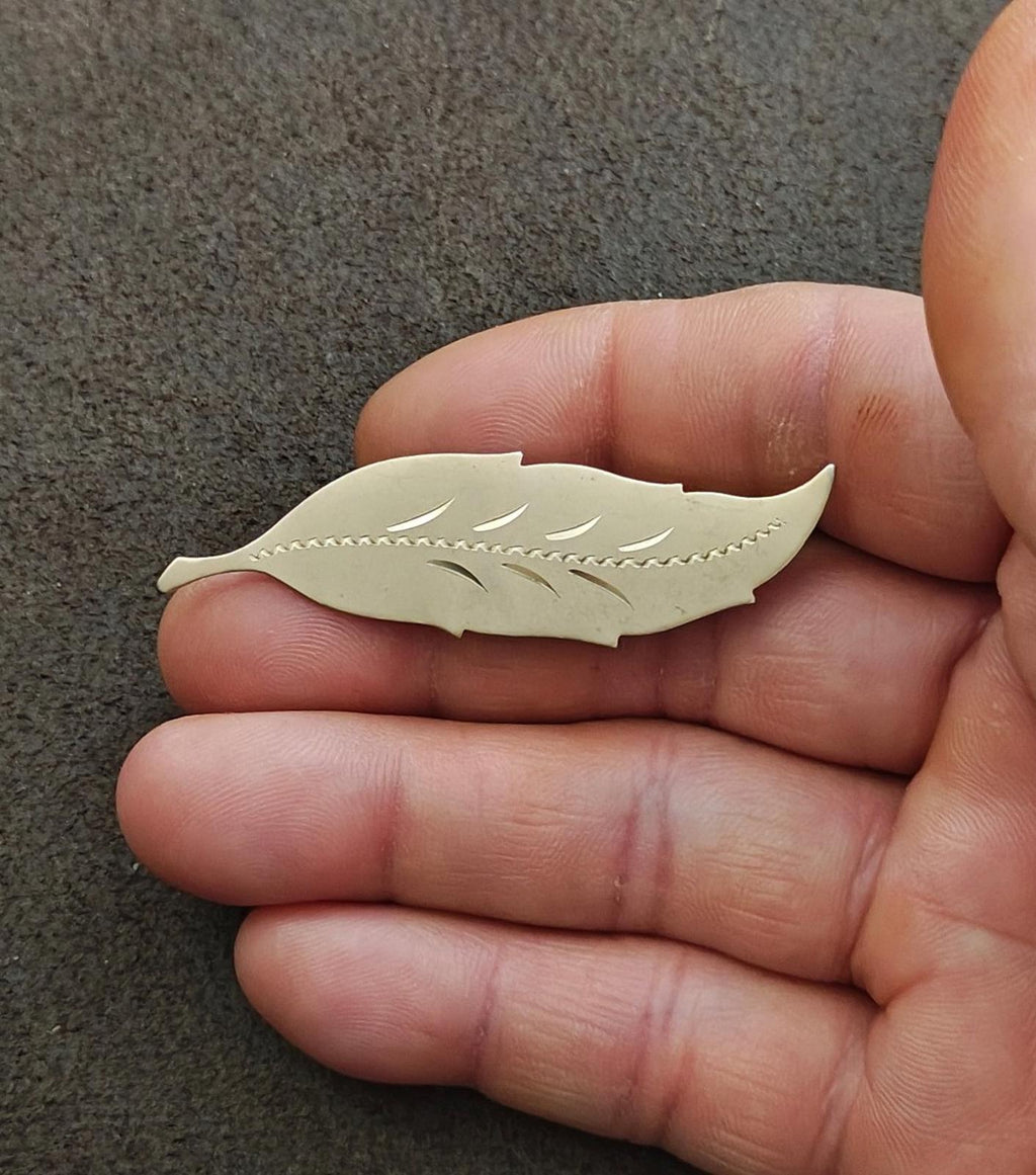 Gold leaf brooch showing etched leaf veins and ribbed center
