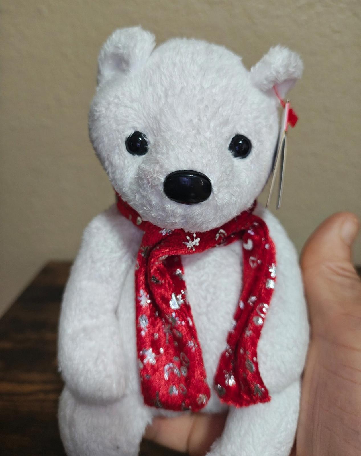 White bear plush with red patterned scarf and hanging red tag