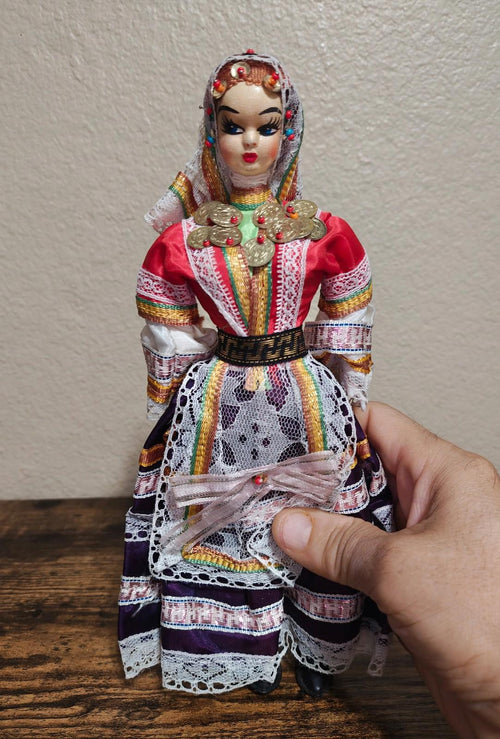 Female folk doll in red and purple embroidered gown with gold coin belt and lace sleeves