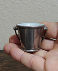 Mini silverplated bucket pail with two loop handles and white interior