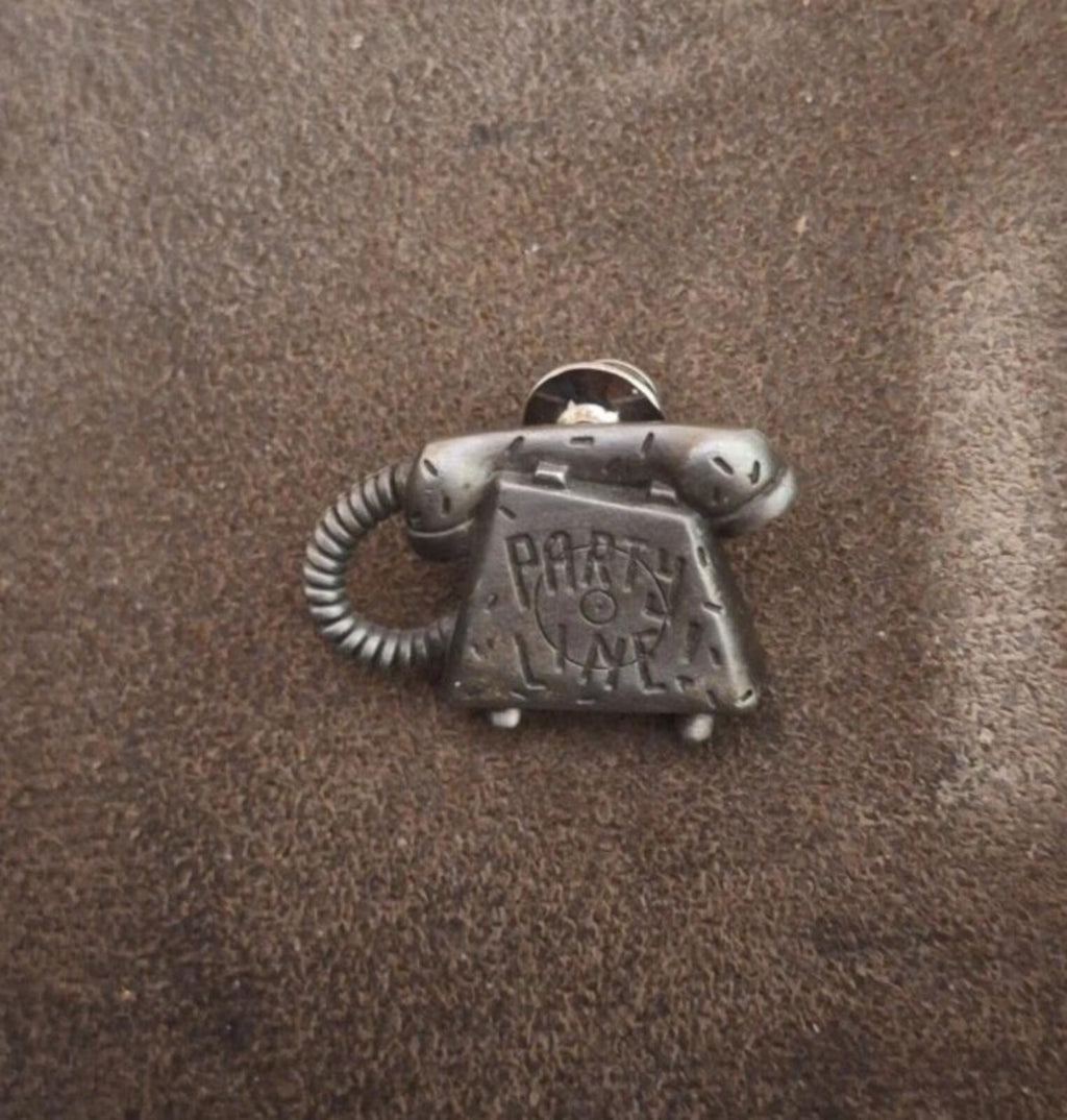 Silver telephone novelty pin with 'PARTY LINE' engraving, front view with coiled cord loop