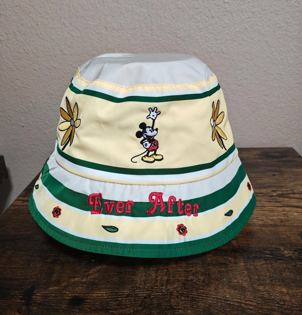 Cream bucket hat on stand with green stripes, Mickey Mouse character, “Ever After” text, flowers