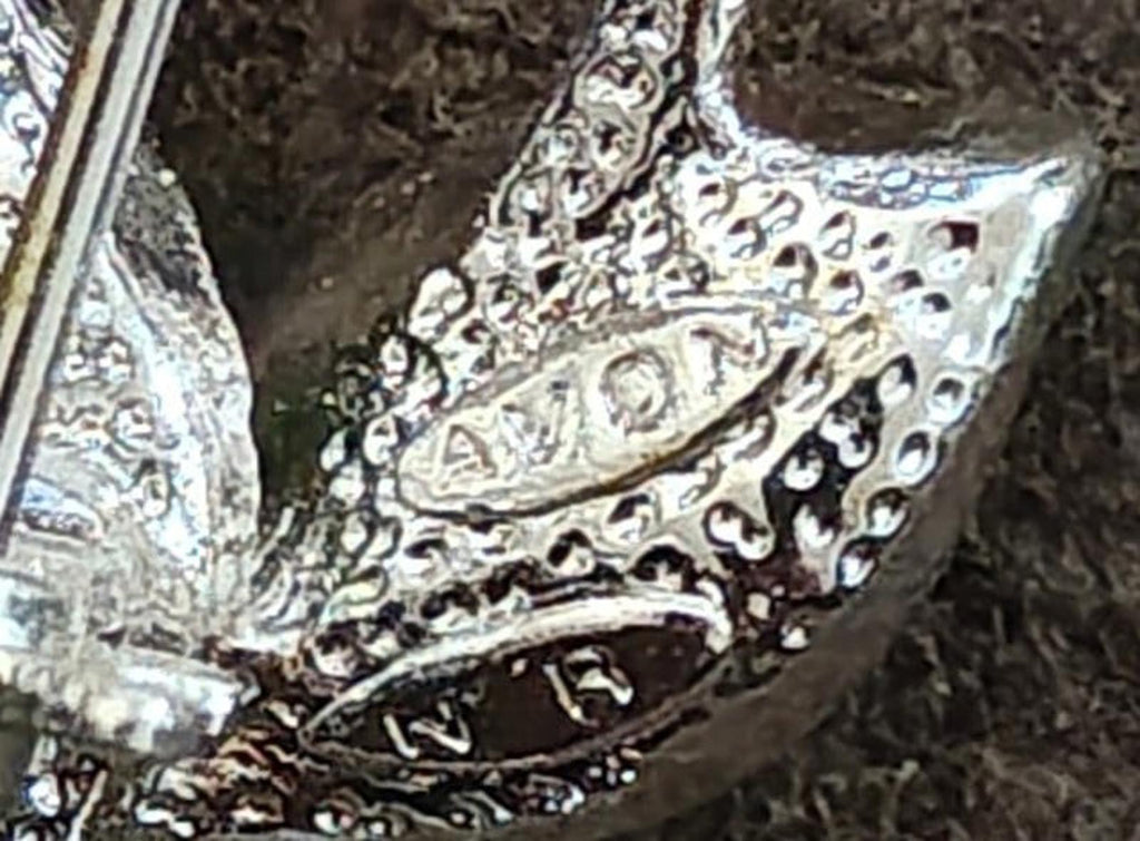 Close-up of silver-tone filigree with clear rhinestone setting detail