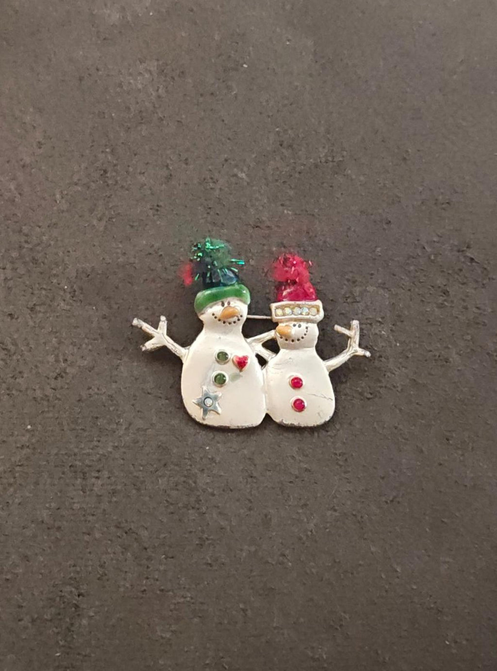 Two snowman enamel brooch with green and red rhinestone tops, silver-tone edging