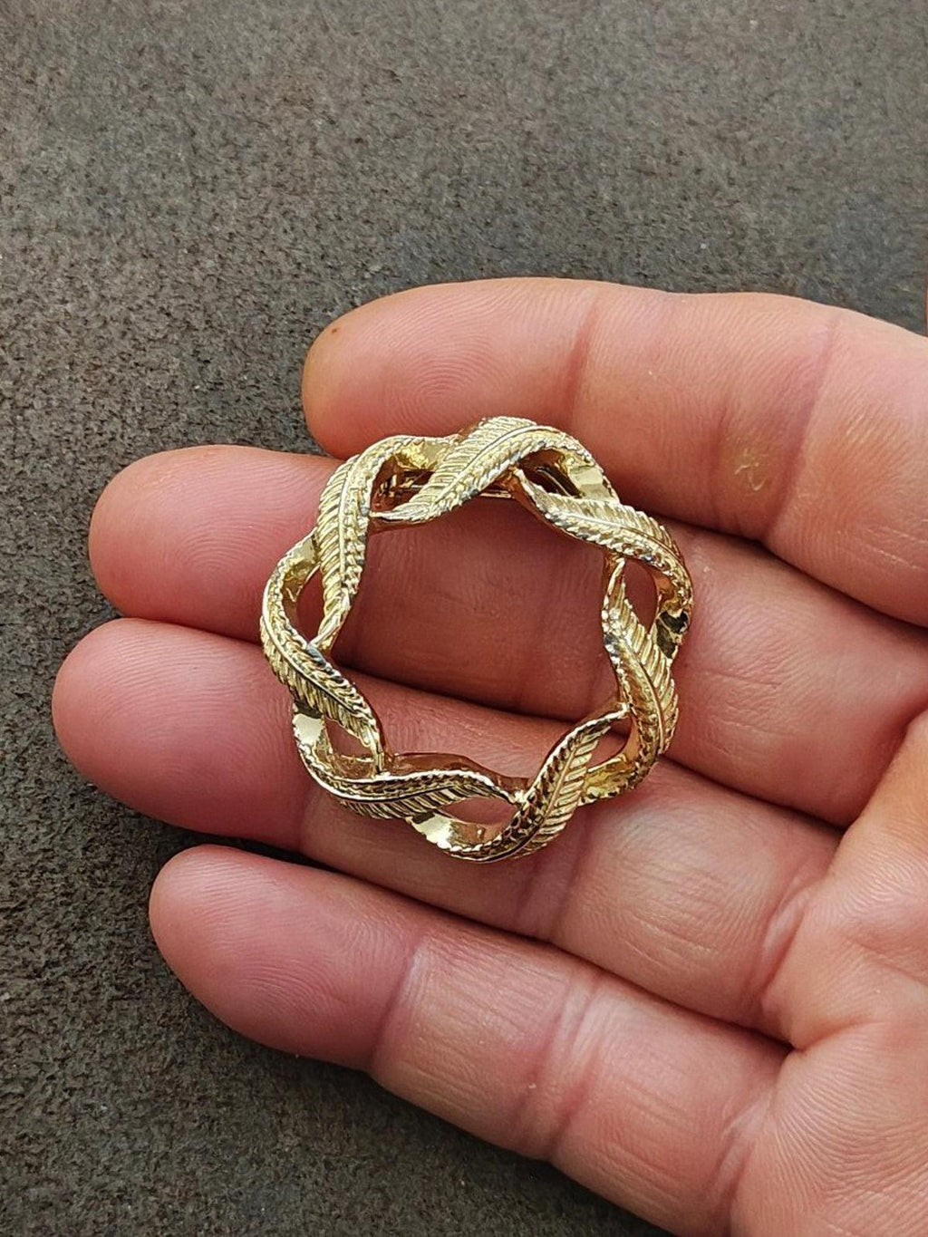 Gold-tone circular wreath brooch pin with twisted rope border and red enamel leaf insets