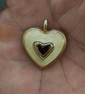 Gold tone heart pendant with white enamel front and black heart inset, open bail top