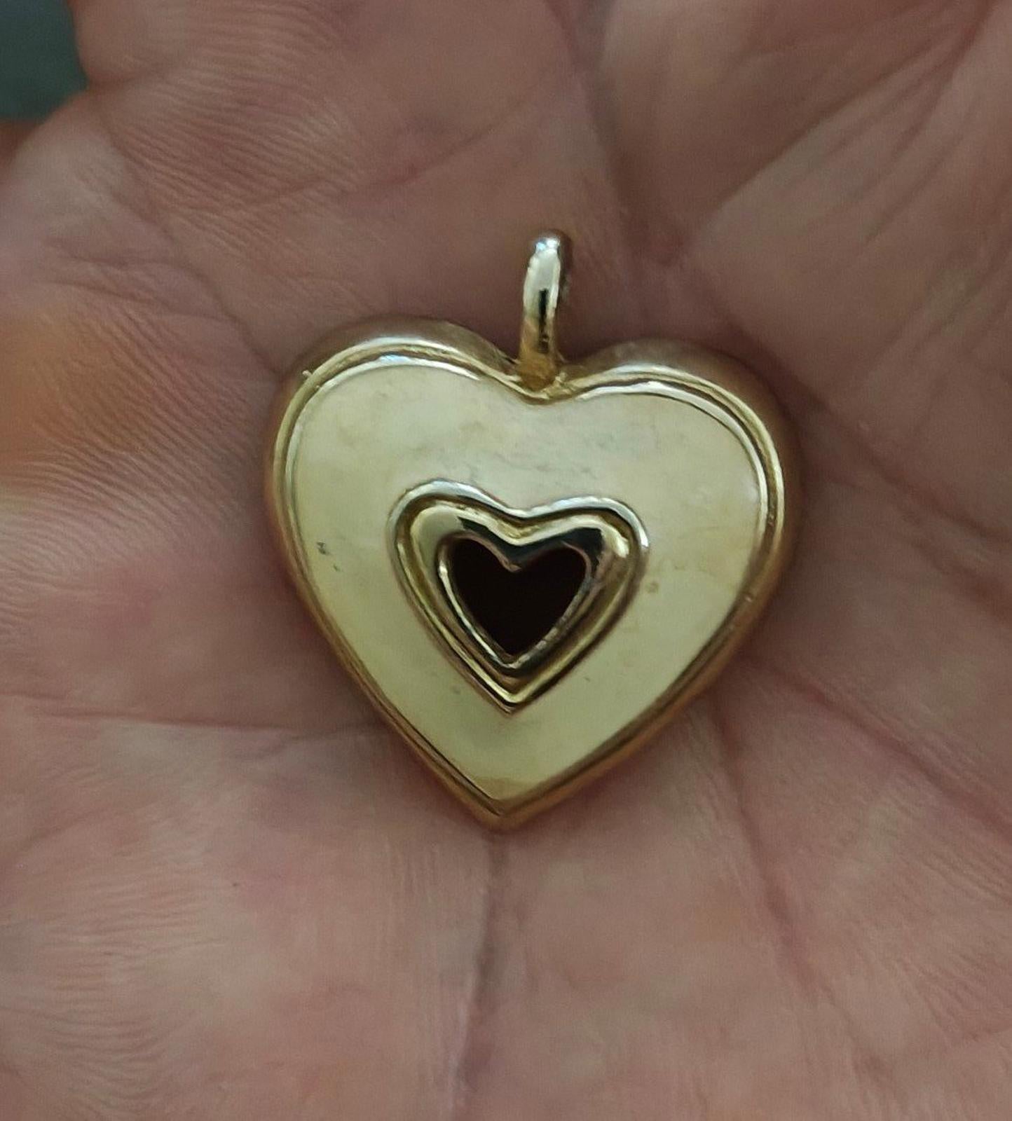 Gold tone heart pendant with white enamel front and black heart inset, open bail top