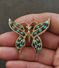 Gold-tone butterfly brooch with faux turquoise enamel wings and central body details