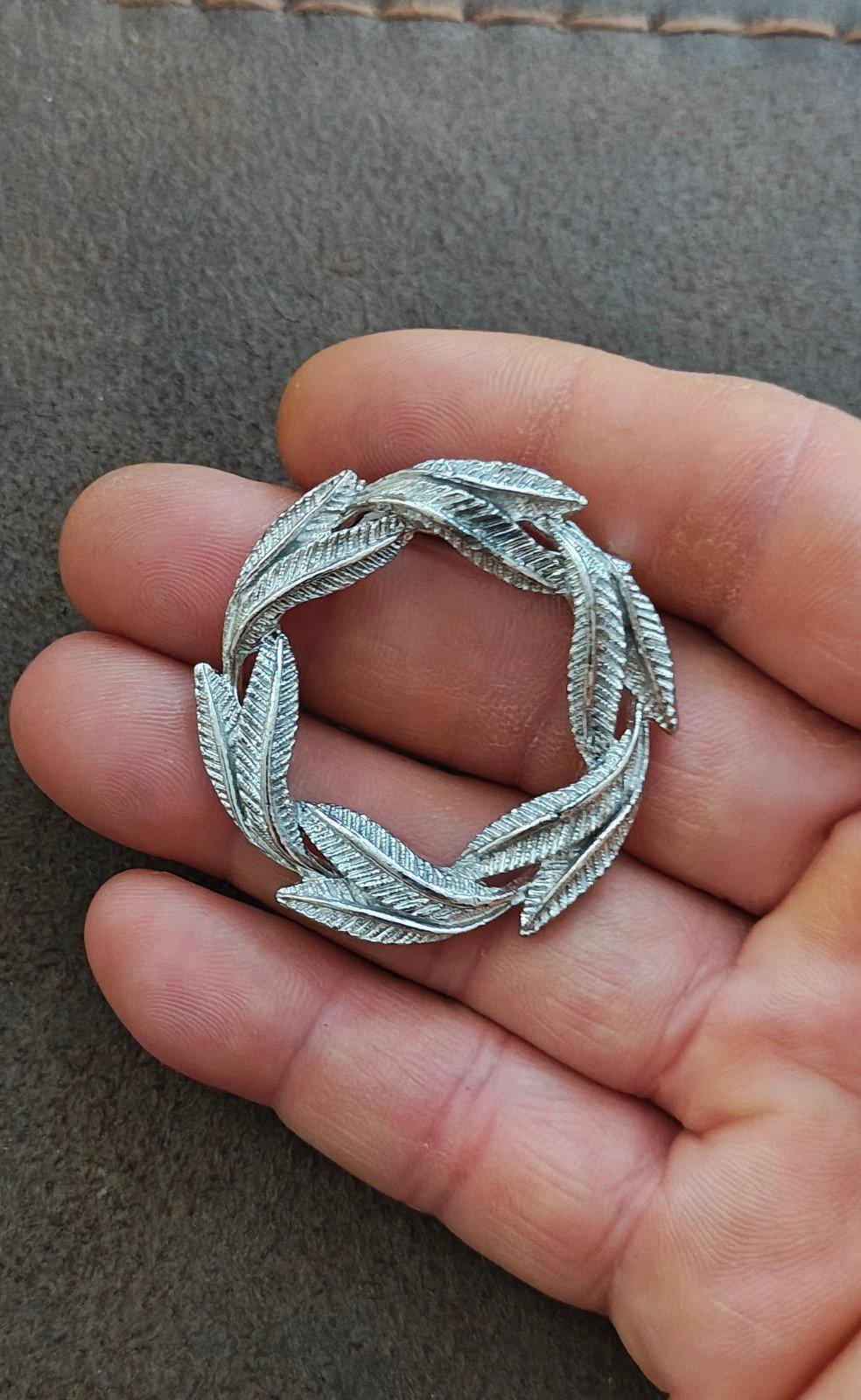Silver-tone circular leaf textured pin brooch with open center, leaf ring detail
