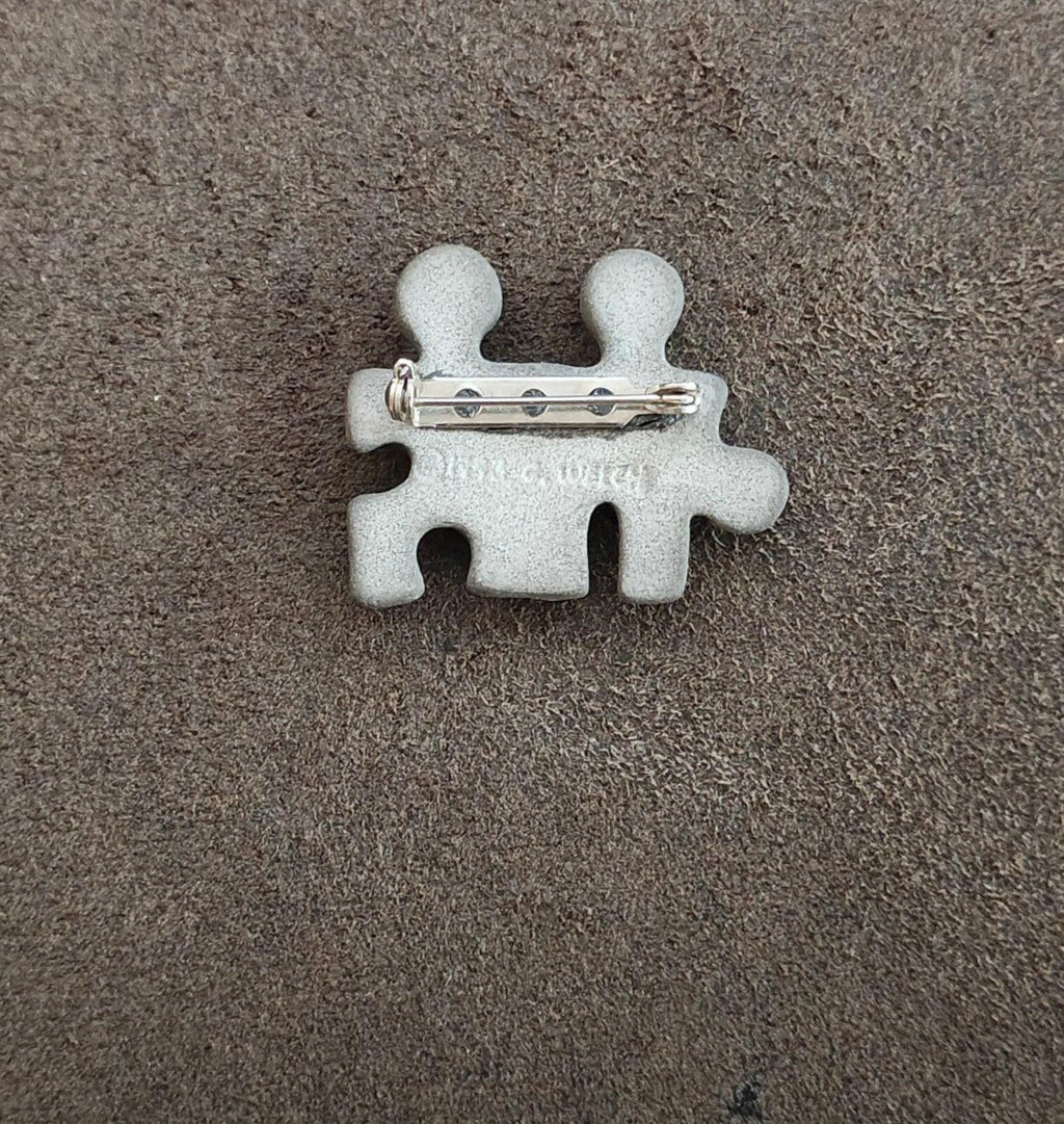 Puzzle buddy brooch back view with metal pin and two-tone figure cutouts
