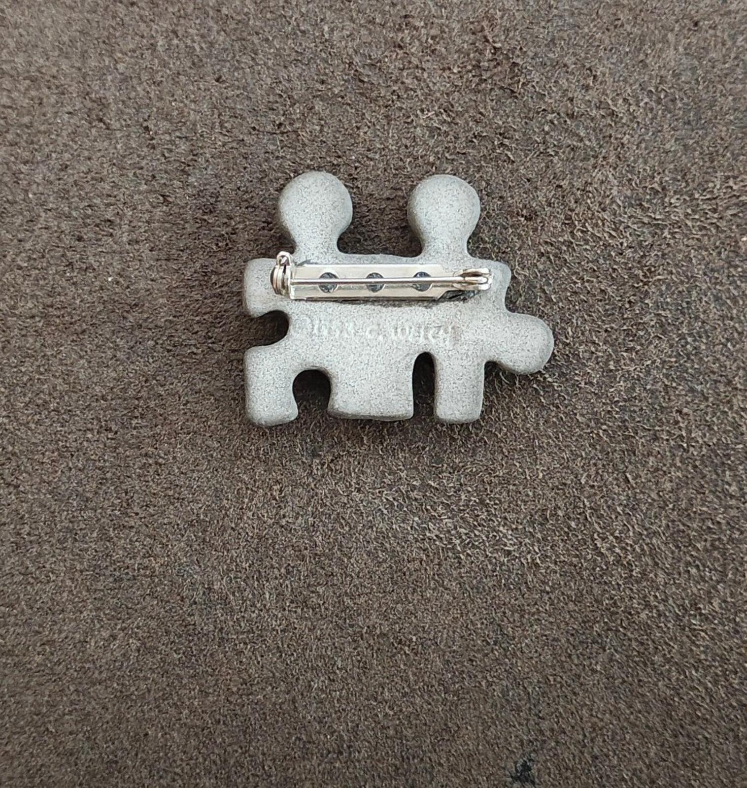 Puzzle buddy brooch back view with metal pin and two-tone figure cutouts