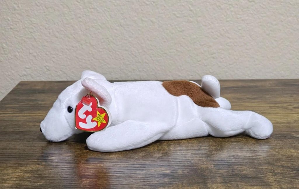 White plush dog lying on side with red Ty heart tag on ear