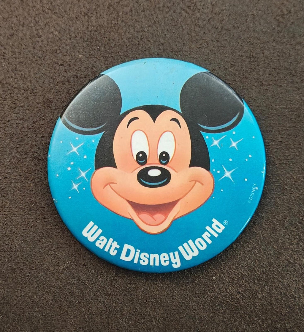 Blue Mickey Mouse pinback button close-up, smiling face with starry background and Walt Disney World text
