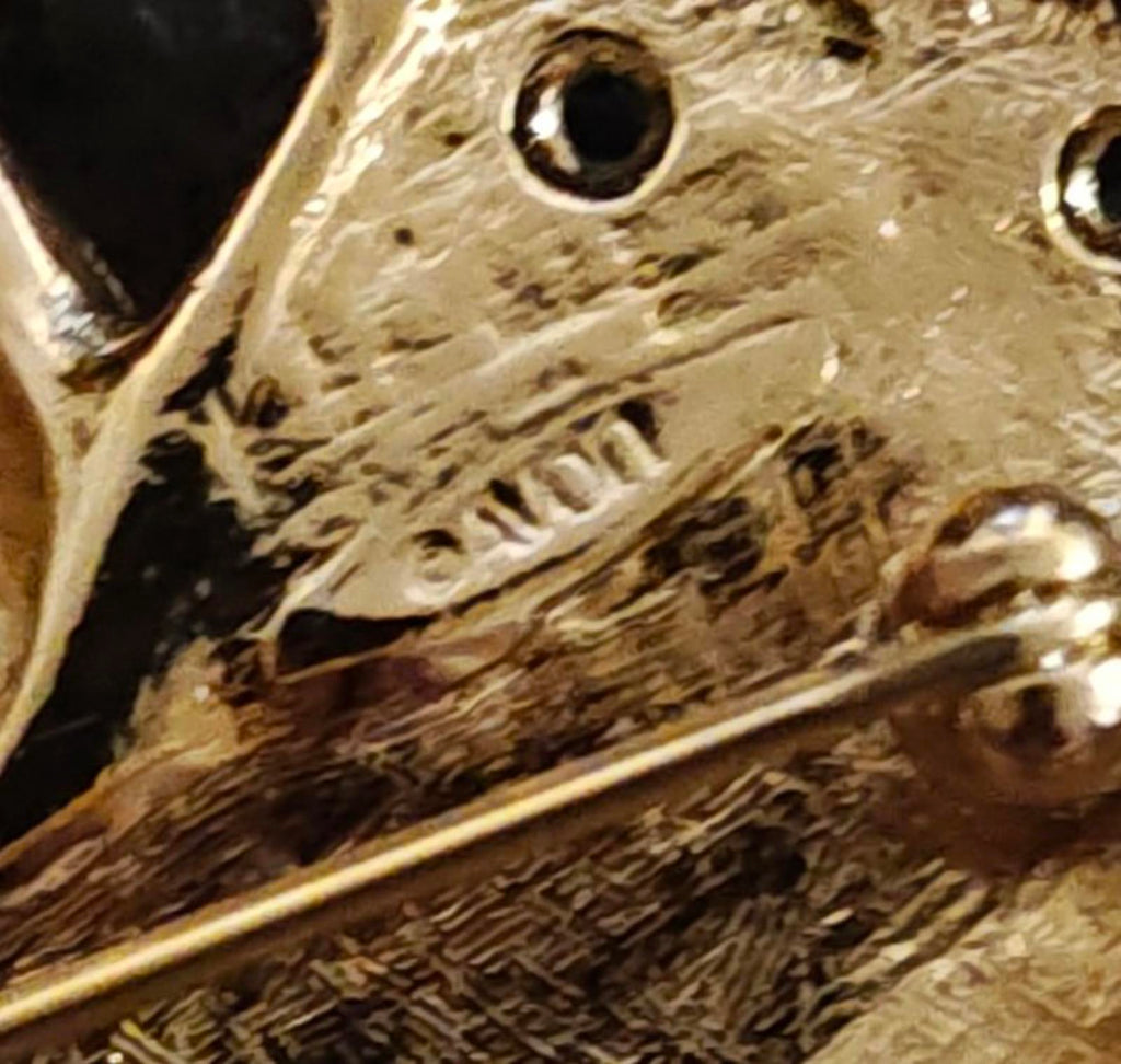 Gold-tone close-up of textured metal base on Santa sleigh brooch