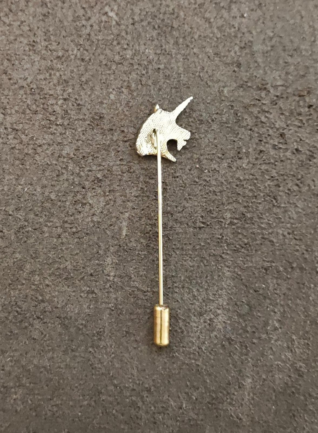 Gold tone unicorn head stick pin with small cylindrical base, straight pin stem