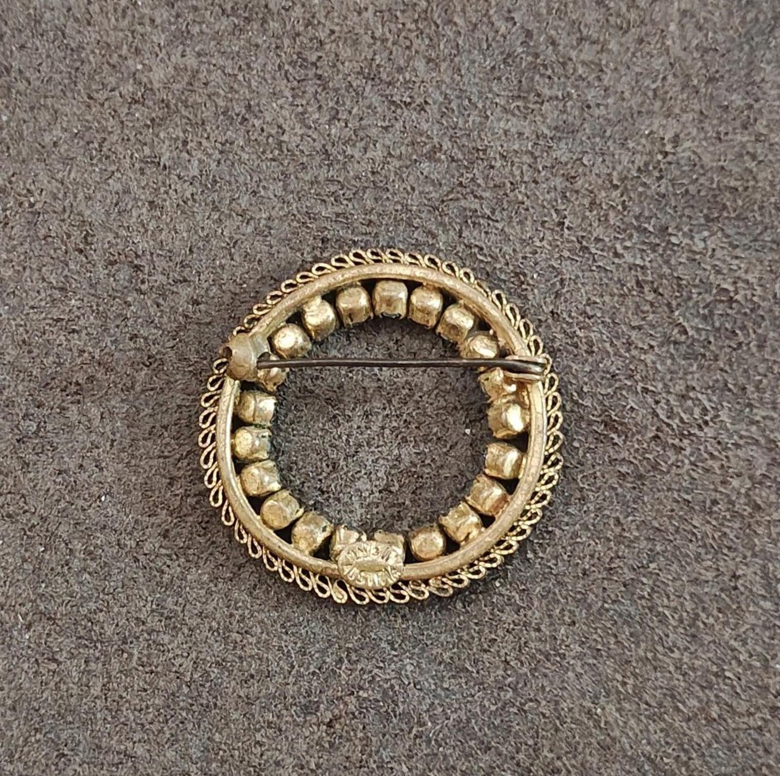 Gold-tone round brooch back with raised bead details and central bar