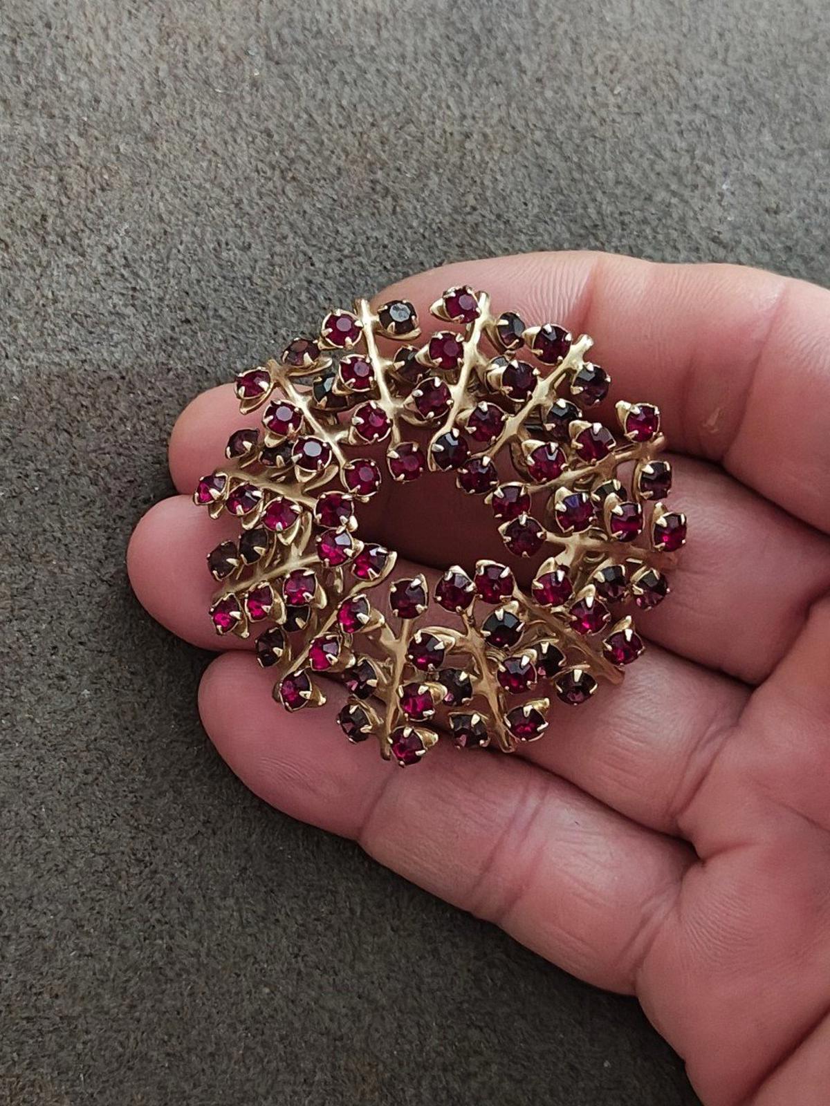 Gold-tone maroon rhinestone brooch pin with dark accent stones, close-up