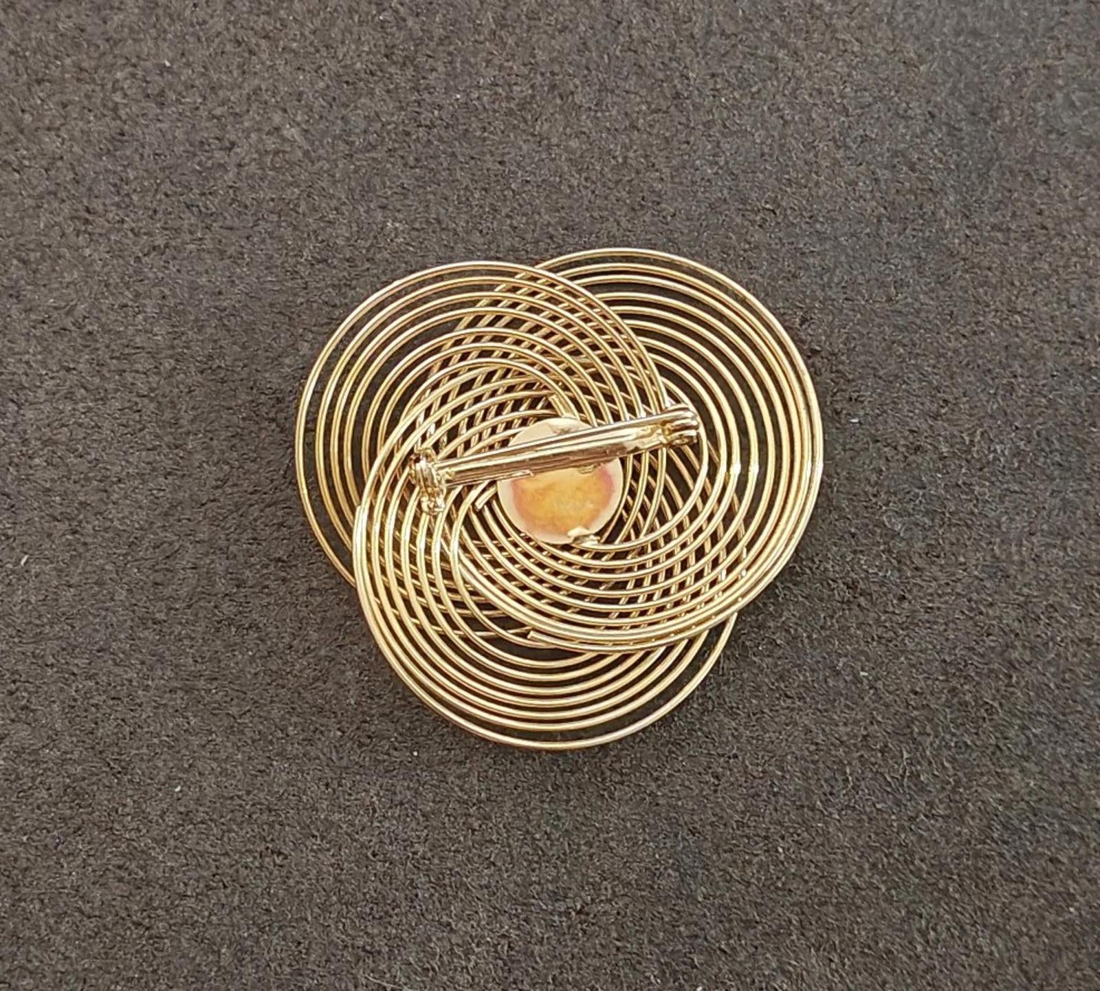 Gold tone wire spiral brooch with concentric coils and small inset stone