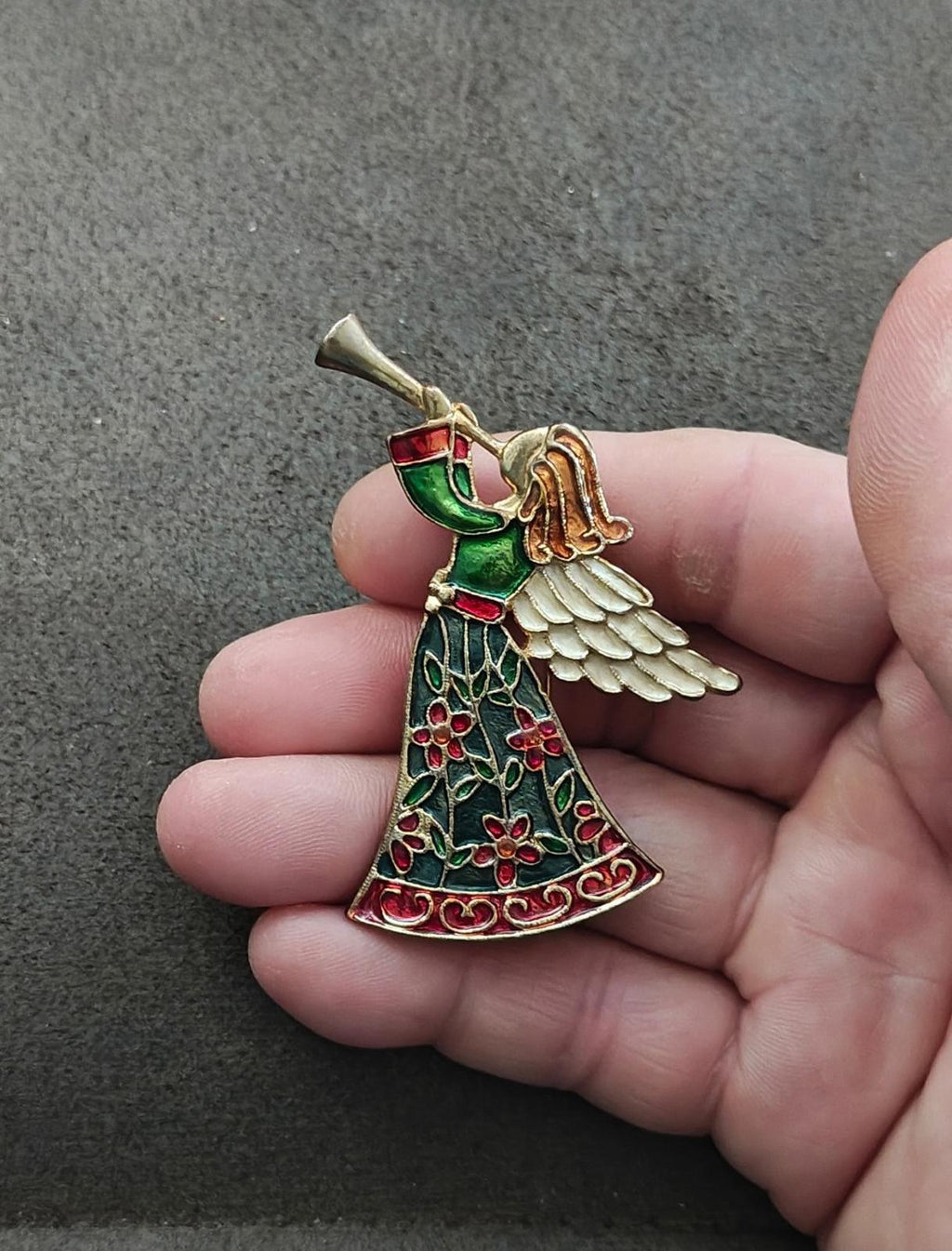 Enamel angel blowing horn brooch pin, gold-tone wings and red-green enamel dress accents