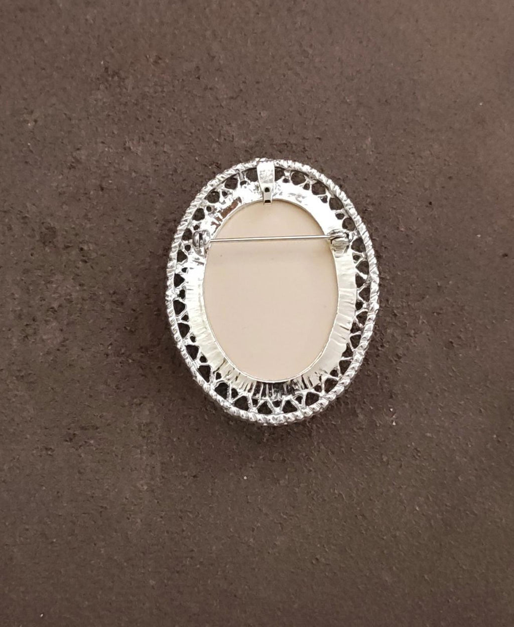 Silver-tone oval brooch back with openwork edge and pin bar