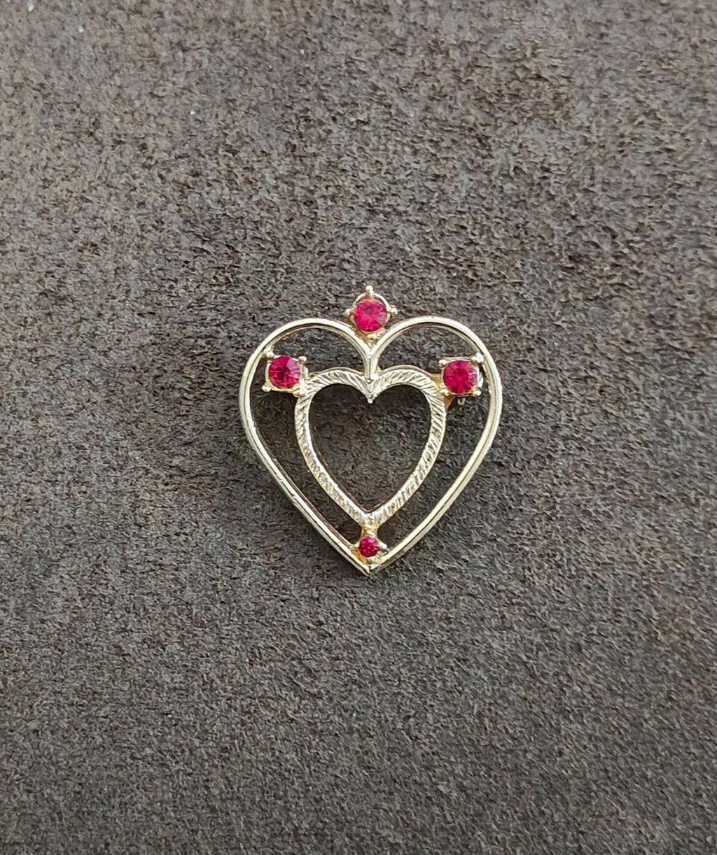 Gold-tone heart-shaped rhinestone brooch pin with red stones, front view