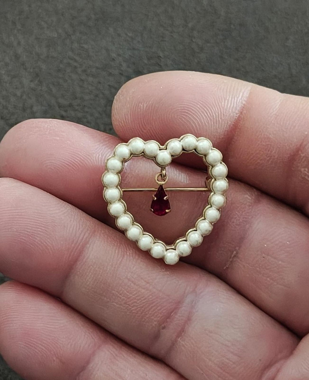 Gold-tone heart brooch featuring white faux pearl beads and a red teardrop rhinestone charm