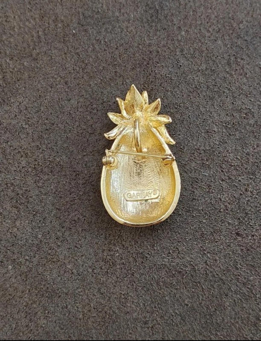 Gold tone pineapple pendant back with raised leaf top and small maker mark