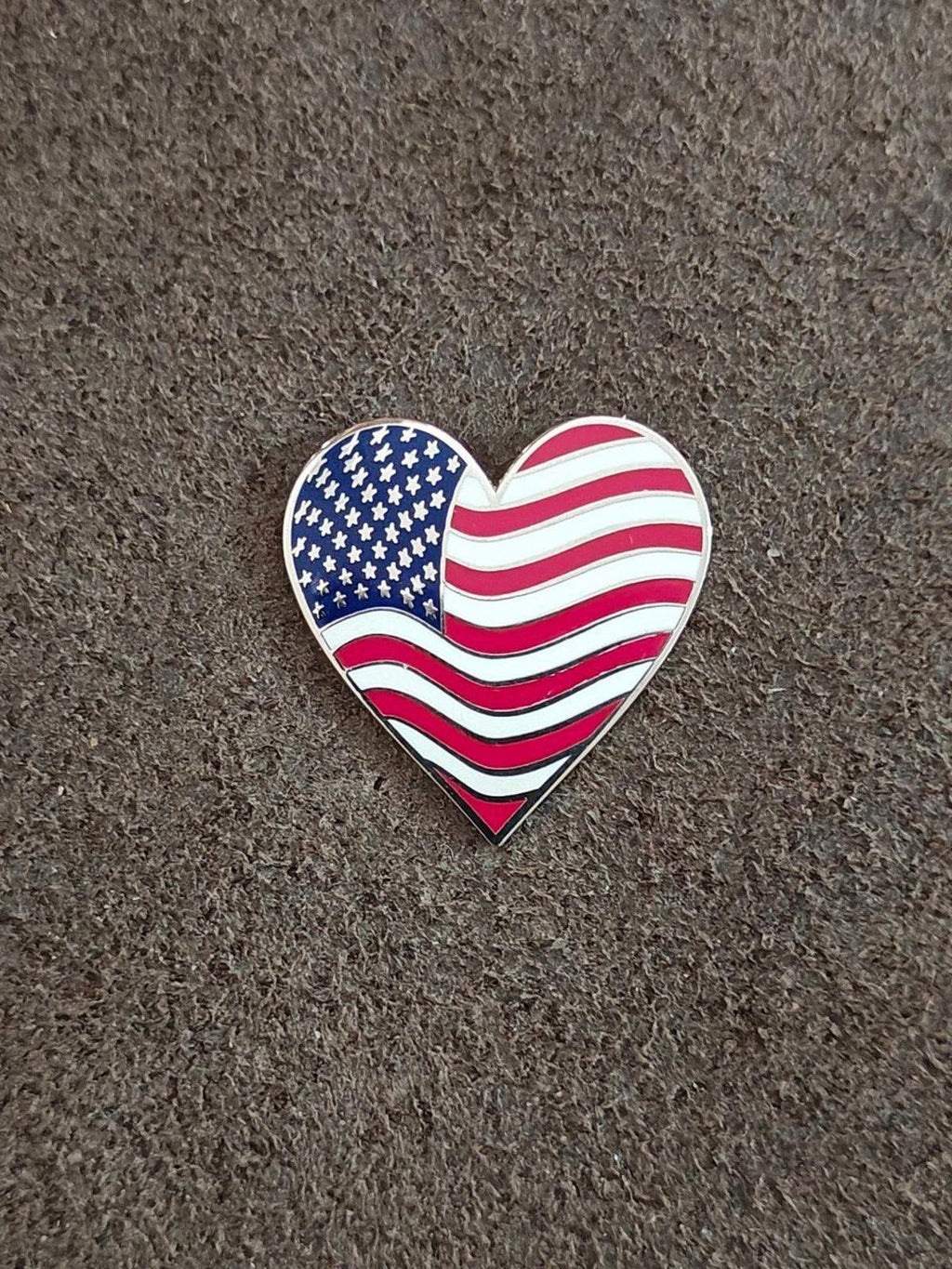 Small heart-shaped American flag enamel pin with blue stars and red/white wavy stripes