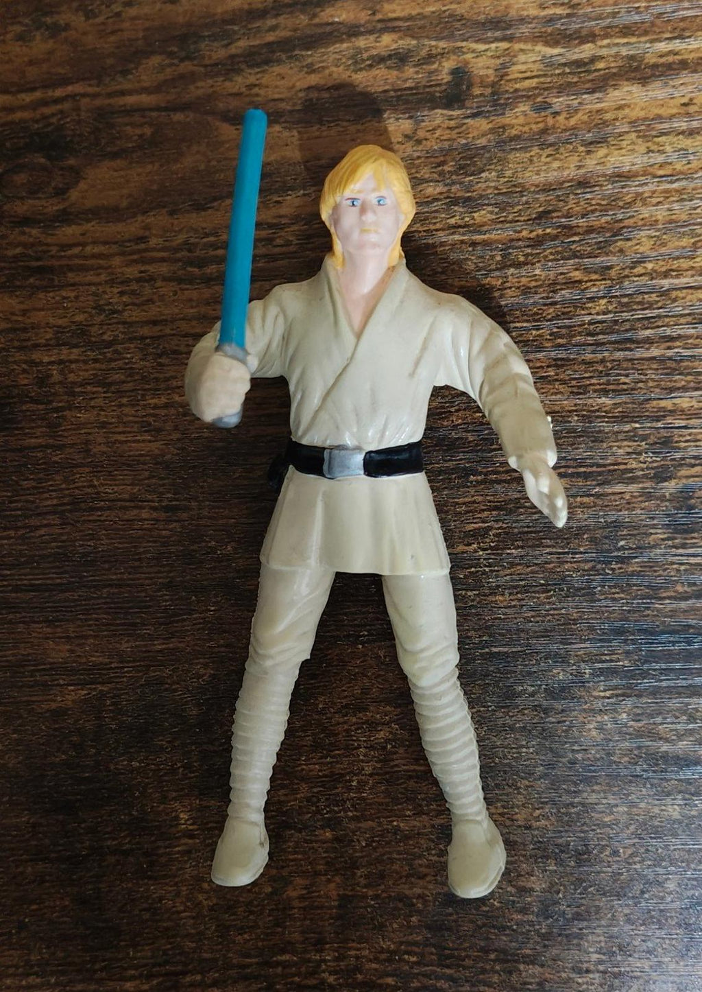 Luke Skywalker bendable action figure standing with blue lightsaber, cream tunic