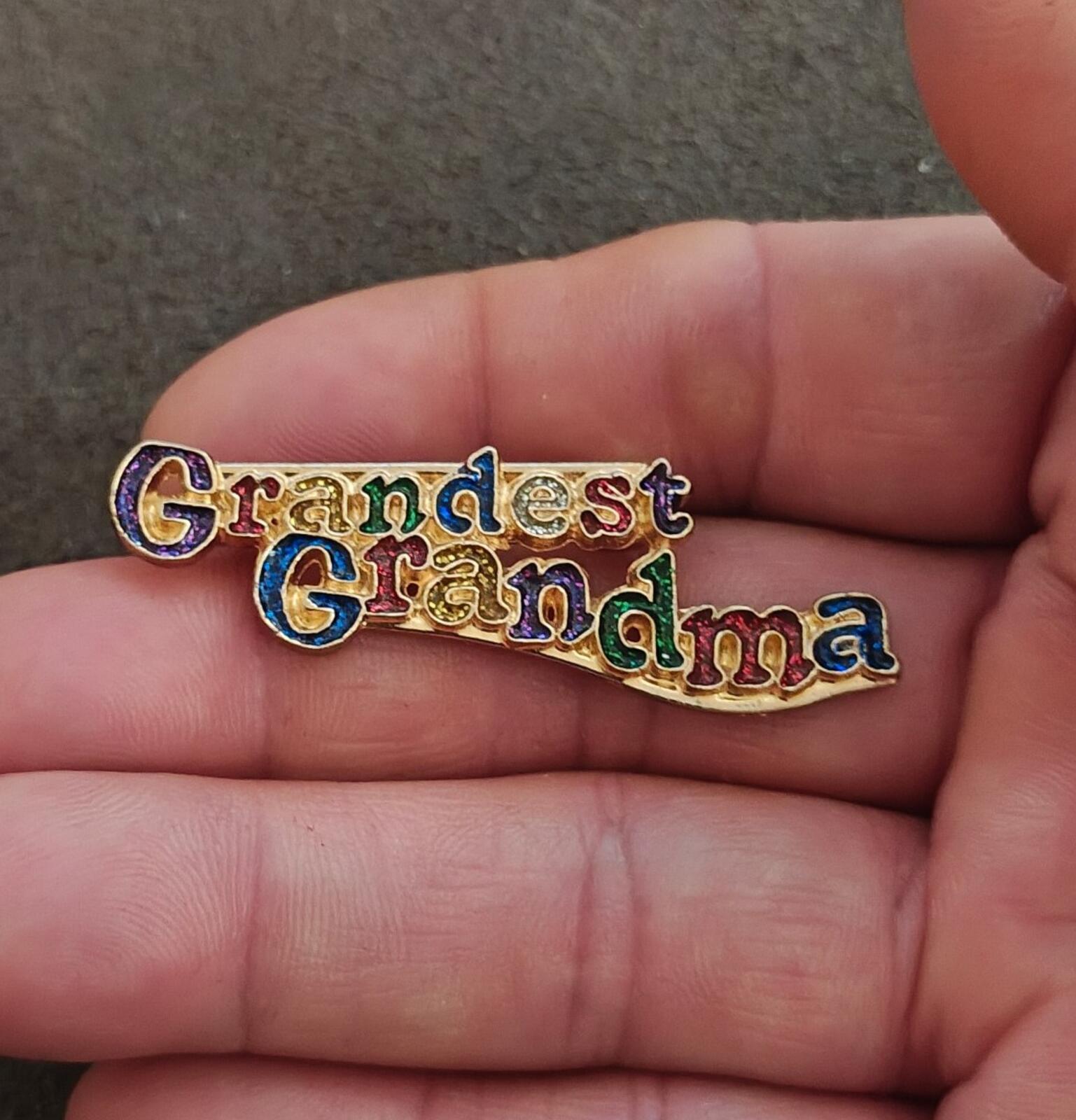 Grandma enamel brooch held in hand, 'Grandest Grandma' multicolor script