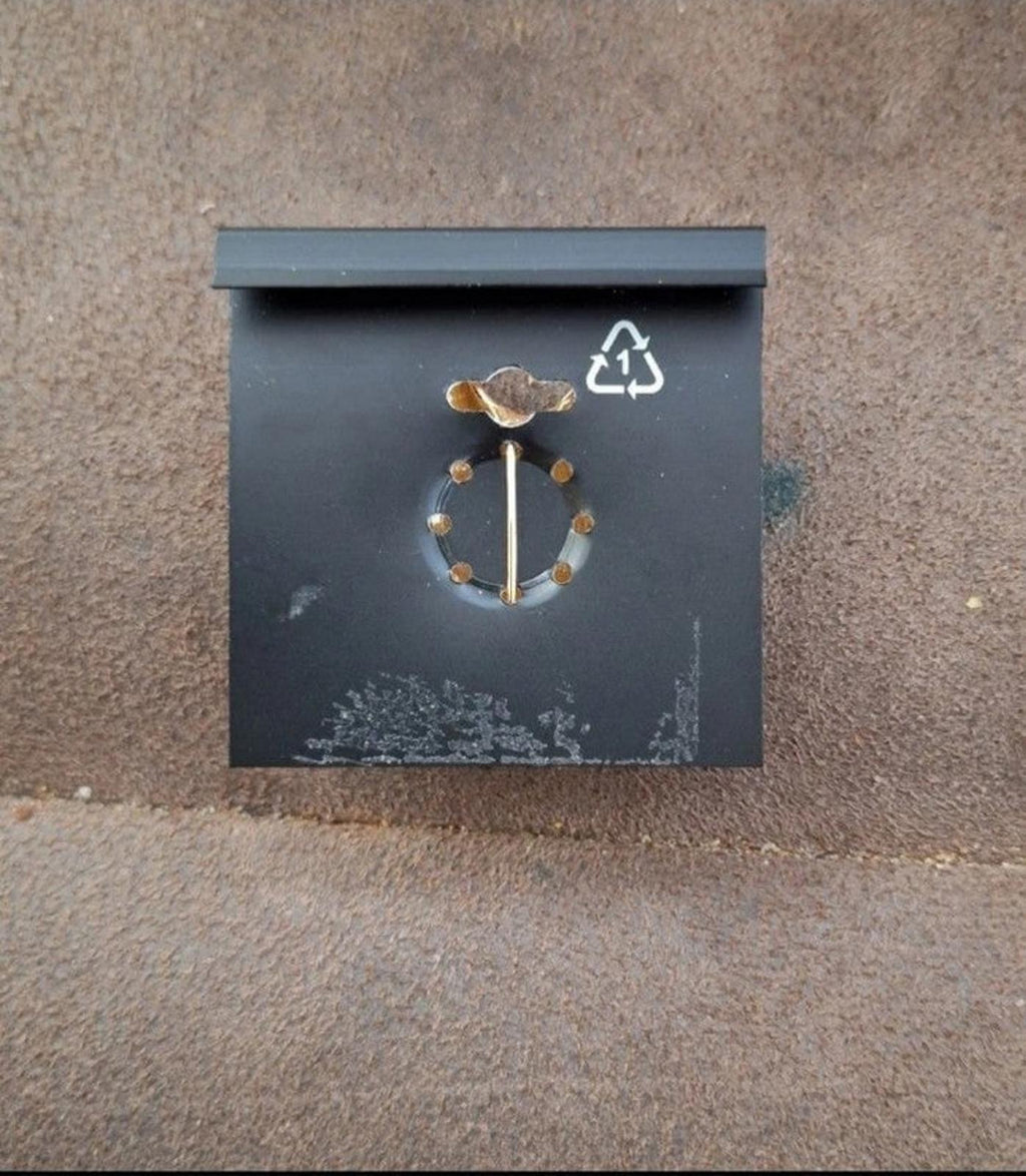 Enamel pin back with circular clasp and recycling symbol on backing card