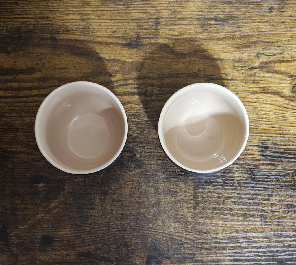 Inside view of two white-glazed stoneware cups with smooth round bottoms