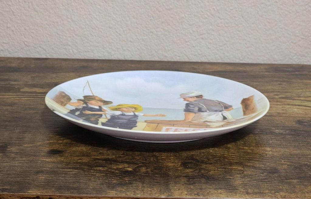 Blue ceramic decorative plate shown from the side with printed fish market artwork