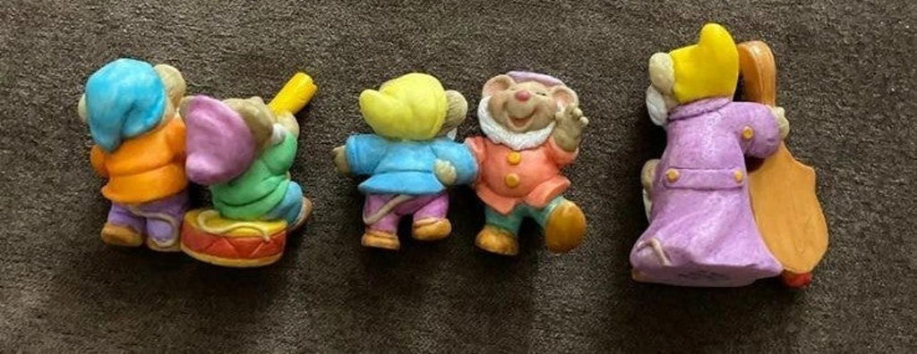 Three dwarf figurines in colorful outfits, shown from different sides and angles.