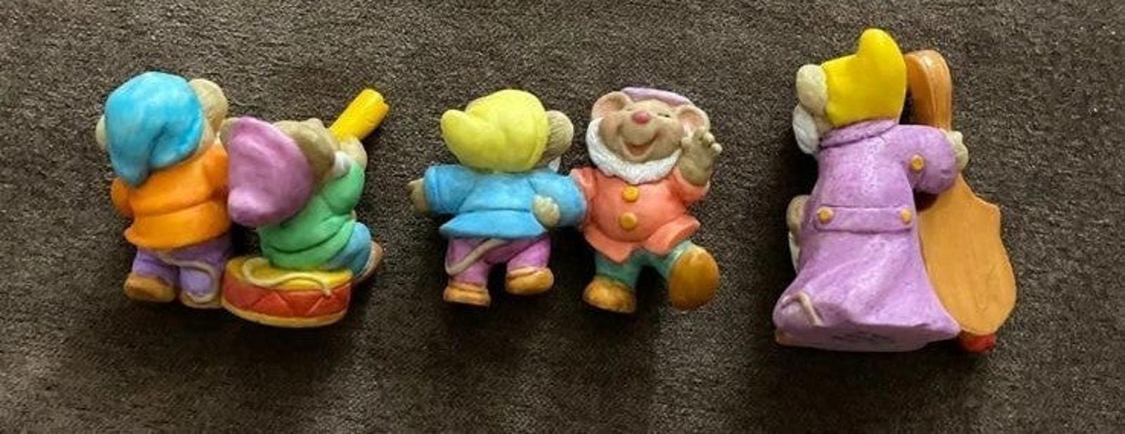 Three dwarf figurines in colorful outfits, shown from different sides and angles.