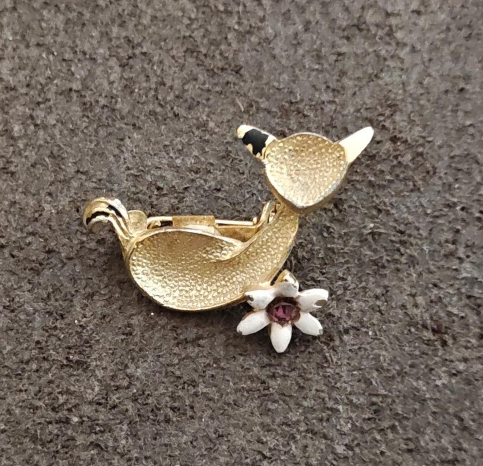 Gold-tone textured cat brooch with white flower and purple rhinestone center