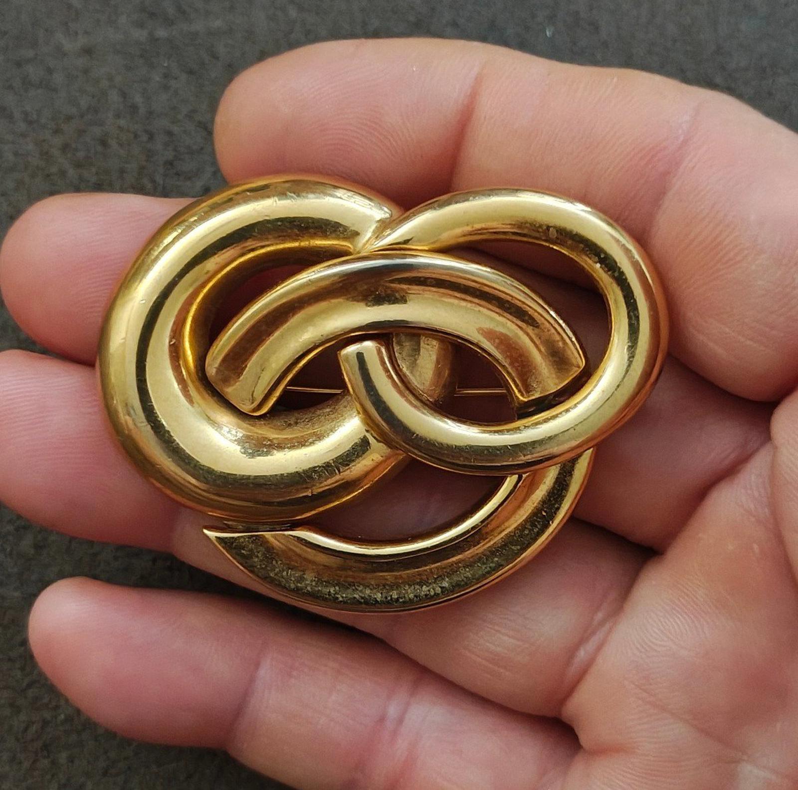 Gold-tone pin brooch with three intertwined circles in a heart-like shape