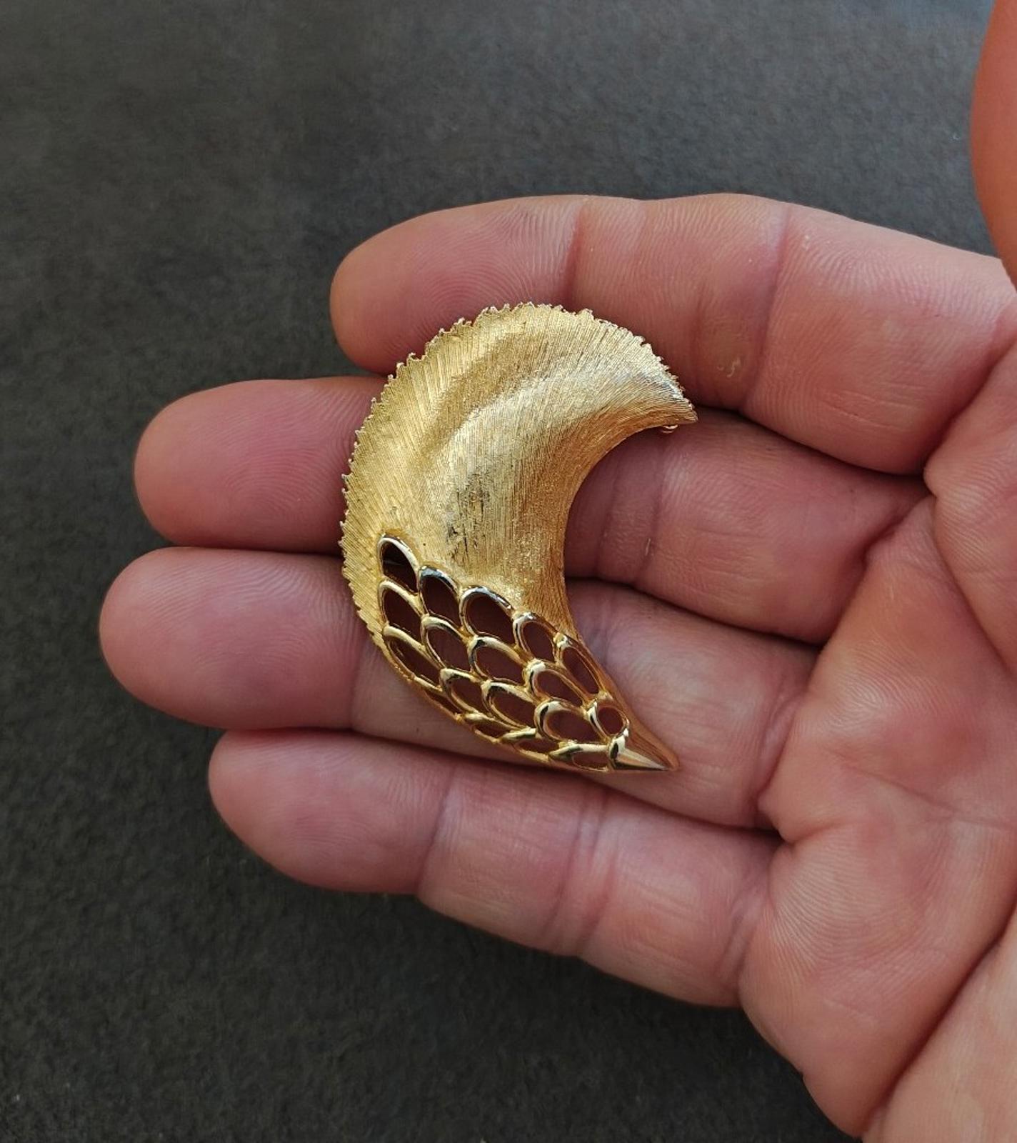 Gold tone crescent feather plume brooch with openwork mesh band and pointed tip