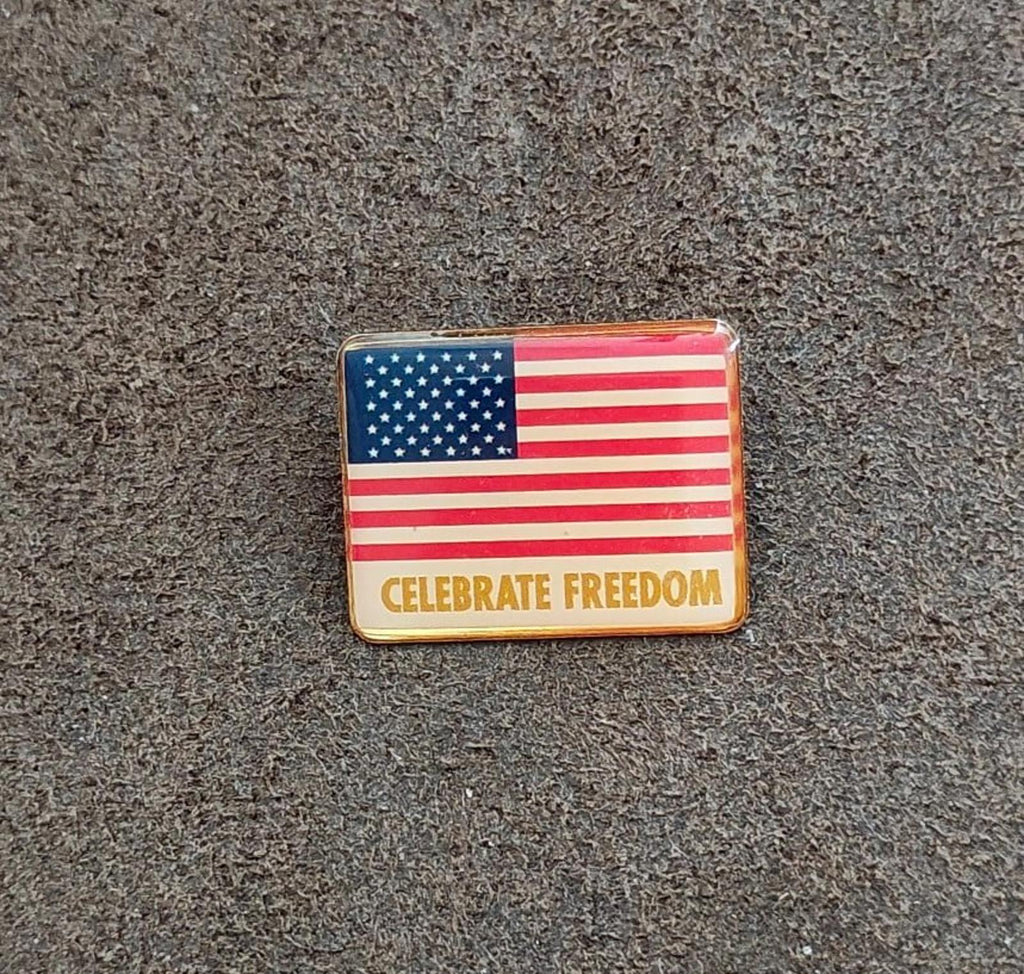 Rectangular gold-tone American flag pin with “CELEBRATE FREEDOM” front text