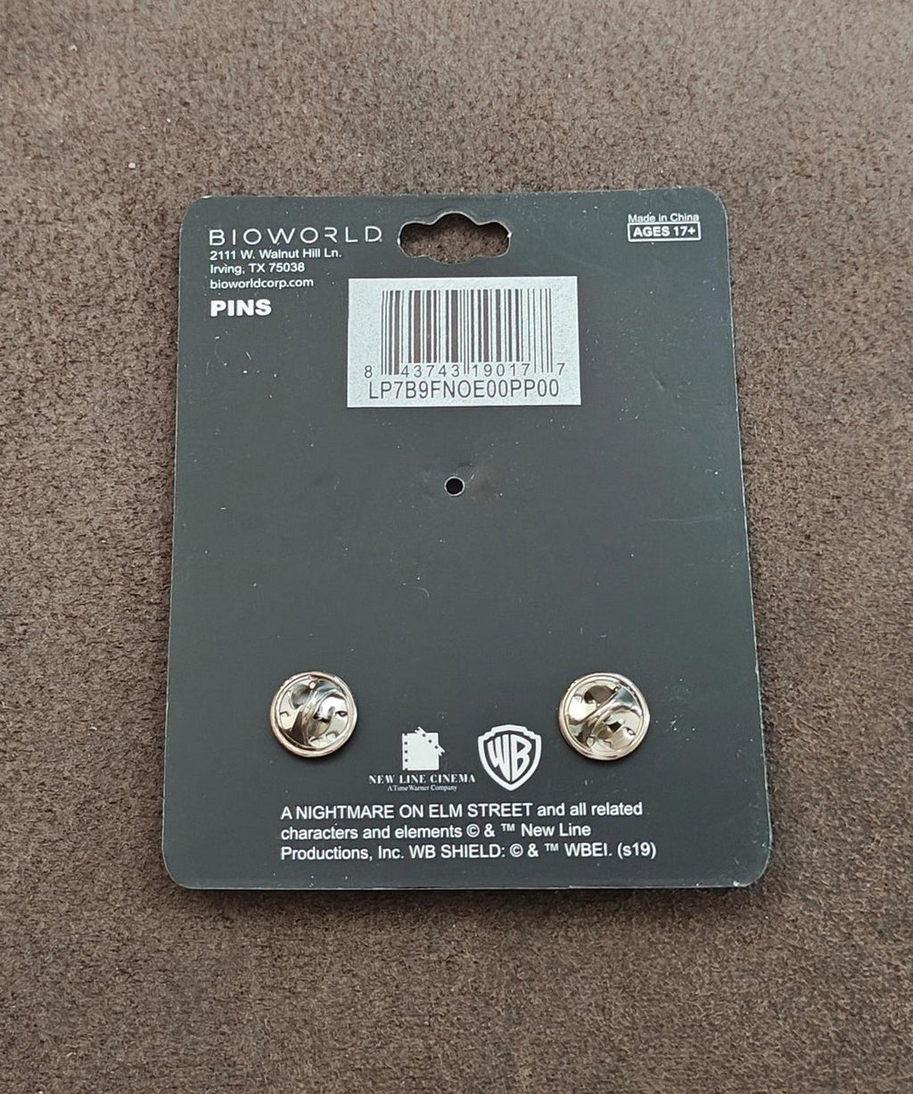 Back of enamel pin set card showing two metal pin backs and brand labeling
