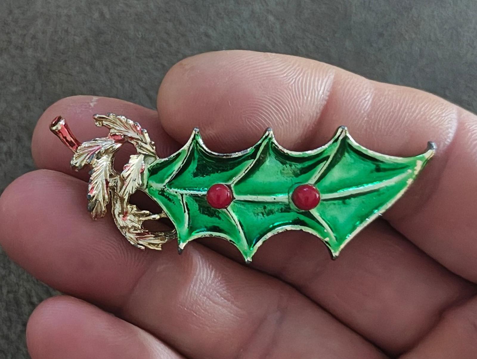 Green holly leaf enamel brooch with gold tone twig detail and red berry accents.
