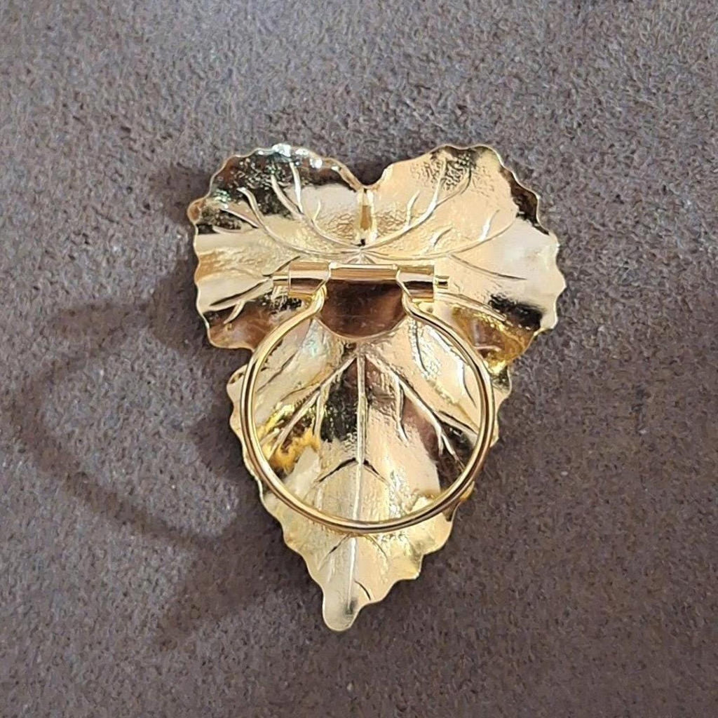 Gold-tone leaf scarf clip backside with hinged bar and circular loop detail
