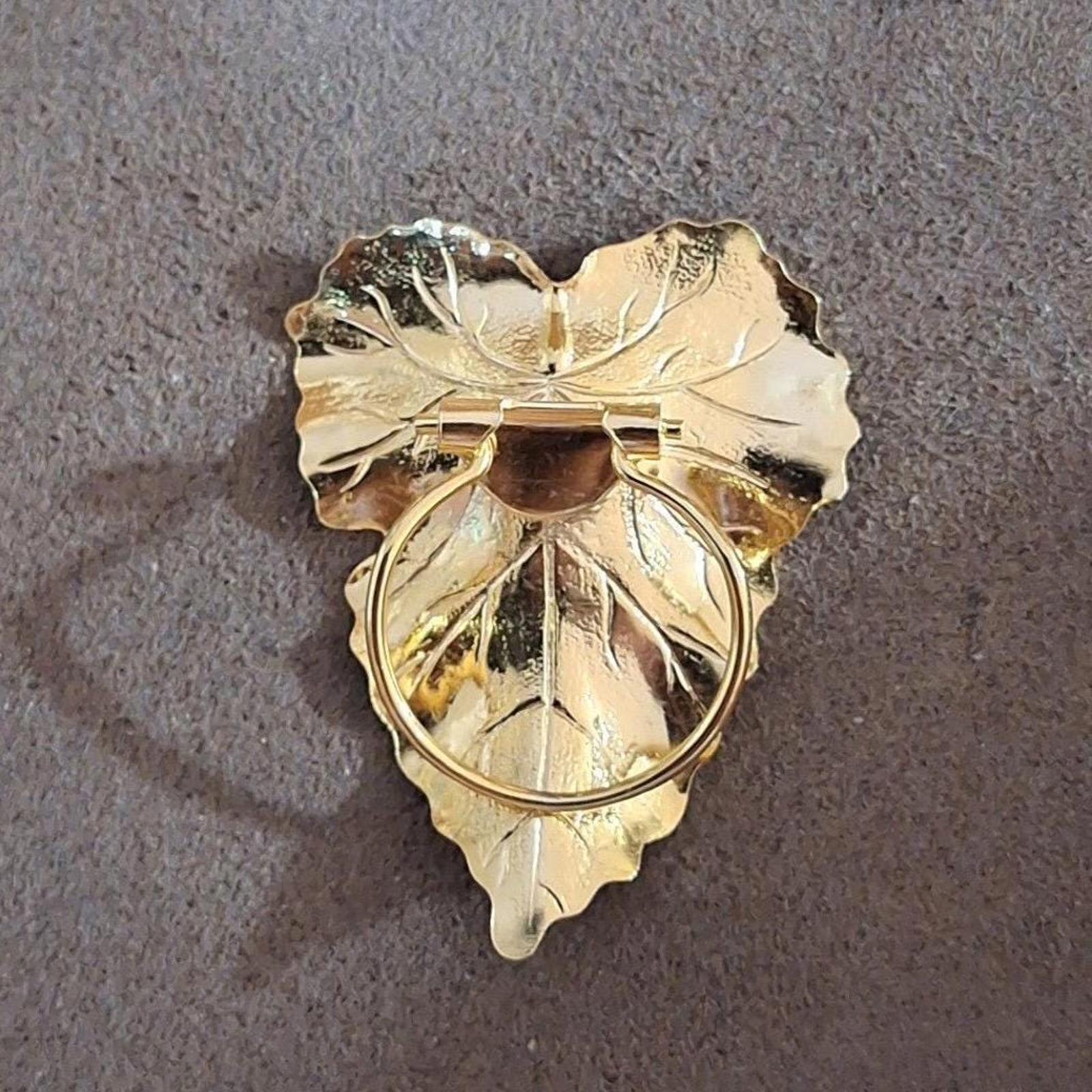 Gold-tone leaf scarf clip backside with hinged bar and circular loop detail