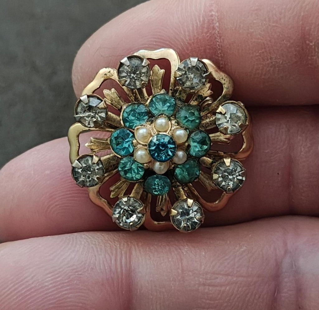 Gold-tone floral sunburst pin with teal center stones, faux pearls, and clear rhinestones