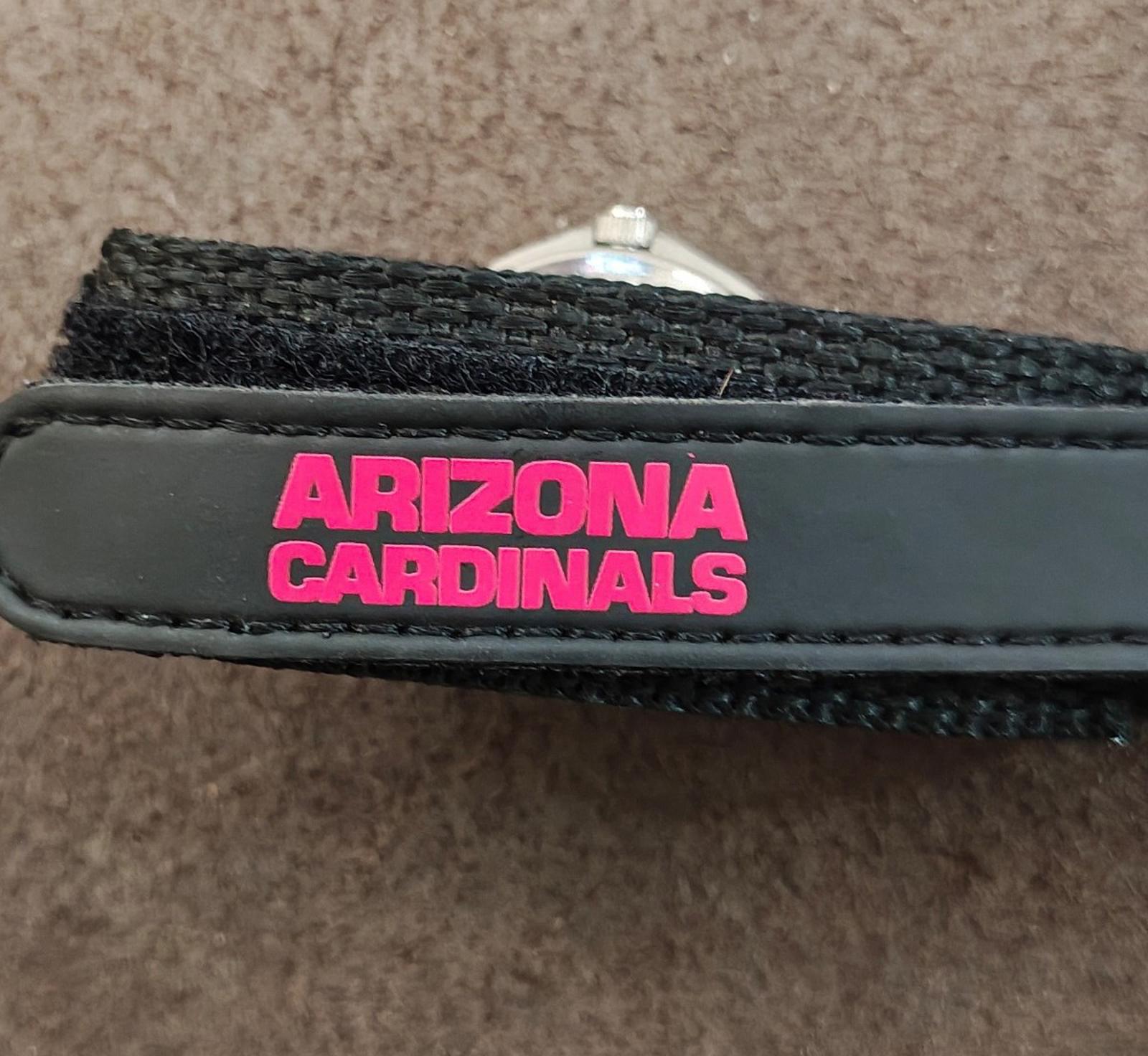 Black watch strap with pink “ARIZONA CARDINALS” text label near metal buckle